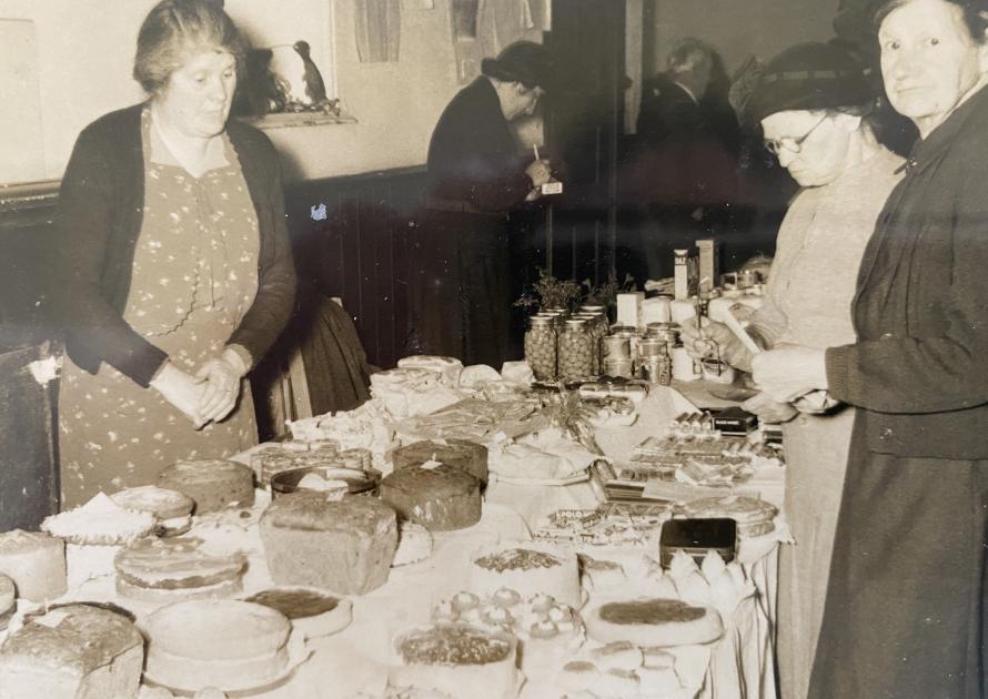 Black and white photo of ladies selling/buying produce.