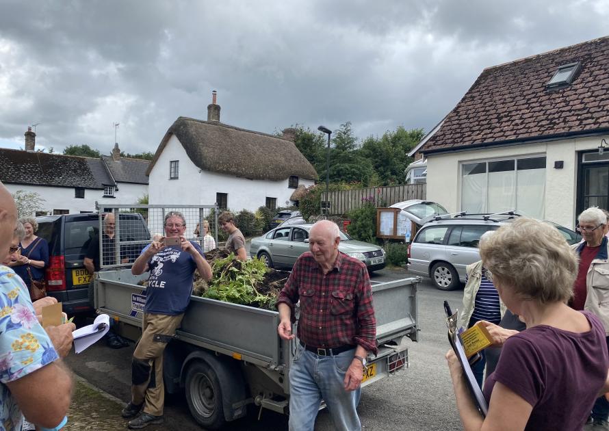 Parishioners in the village square watching potato buckets being emptied and the contents weighed.