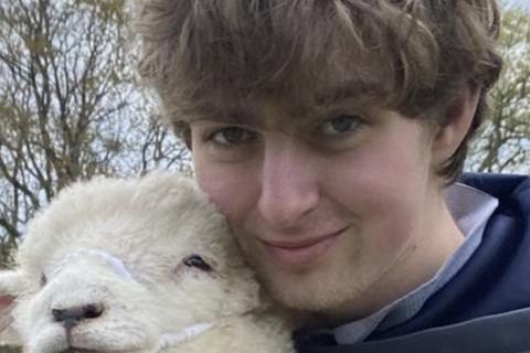 Photo of Tom holding a lamb